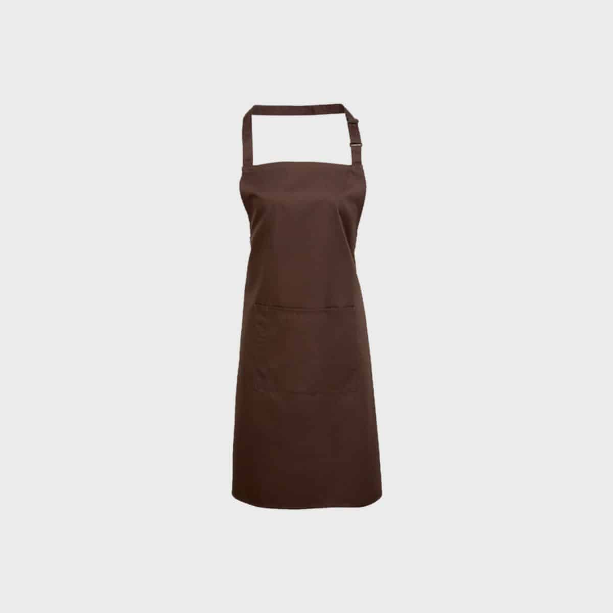 Eine schlichte braune PREMIER WORKWEAR Latzschürze mit Tasche ist vor einem weißen Hintergrund abgebildet. Die Schürze verfügt über einen Nackenriemen und eine große Vordertasche und ihr schlichtes Design umfasst einen verstellbaren Riemen für verschiedene Größen.