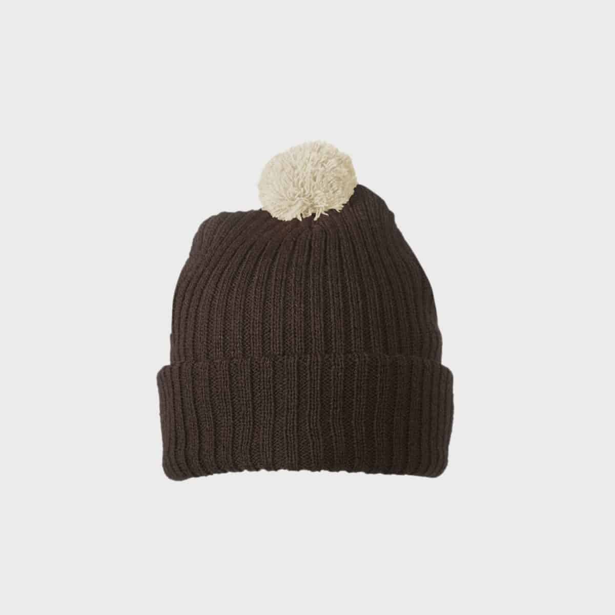 Die MYRTLE BEACH Strickmütze mit Bommel ist eine dunkelbraune, gerippte Strickmütze mit umgeschlagenem Umschlag und einem weißen Bommel oben auf einem schlichten weißen Hintergrund.