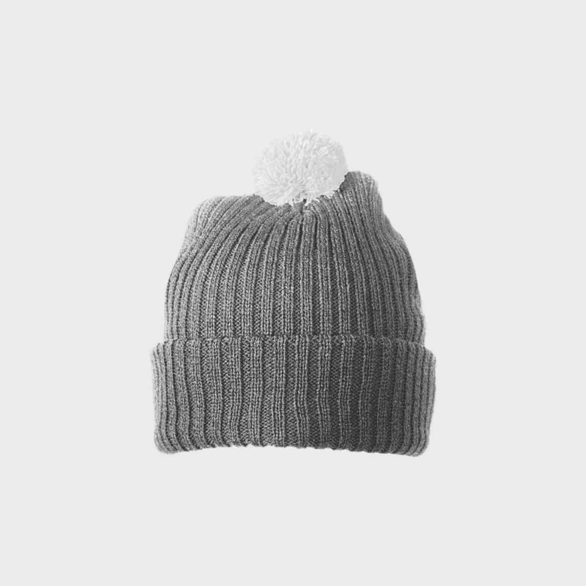 Die MYRTLE BEACH Strickmütze mit Bommel, eine graue Strickmütze mit gefalteter Krempe und einem weißen Bommel oben auf einem schlichten weißen Hintergrund.