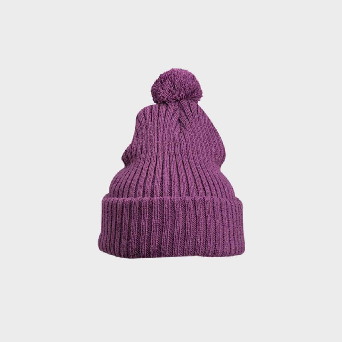 Die MYRTLE BEACH Strickmütze mit Bommel ist eine lila Strickmütze mit einem großen Bommel oben. Dieses kuschelige Accessoire hat eine gerippte Textur und eine gefaltete Krempe, die sein gemütliches Aussehen vor dem schlichten weißen Hintergrund noch verstärkt.