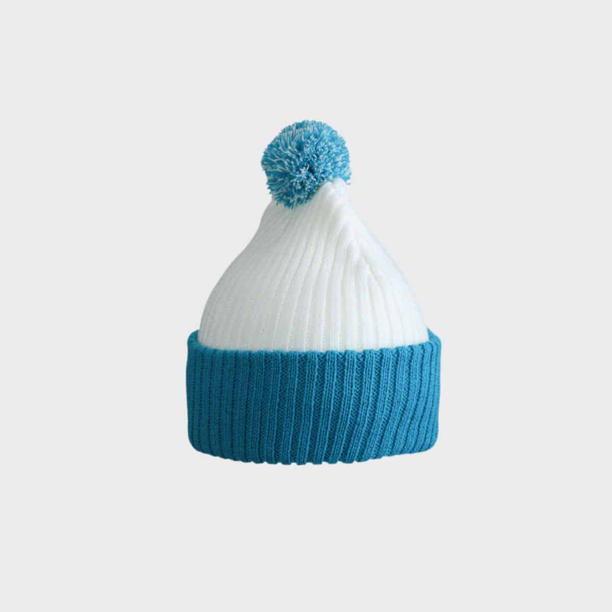 Eine MYRTLE BEACH Strickmütze mit Bommel in Weiß, mit einem blauen gerippten Umschlagbündchen und einem passenden blauen Bommel oben, isoliert auf weißem Hintergrund.