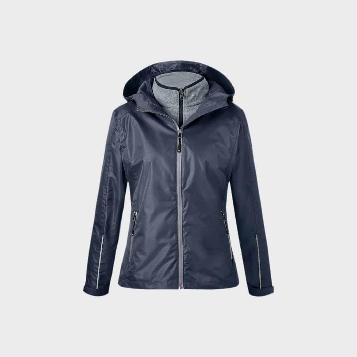 Die 3-in-1-Jacke für Damen, ein Damenoberbekleidungsstück in Marineblau, verfügt über eine Kapuze, einen Frontreißverschluss und Reißverschlusstaschen auf beiden Seiten. Mit einem grauen Innenfutter und verstellbaren Bündchen ist diese Jacke ideal für regnerisches oder windiges Wetter und bietet sowohl Stil als auch Funktionalität.