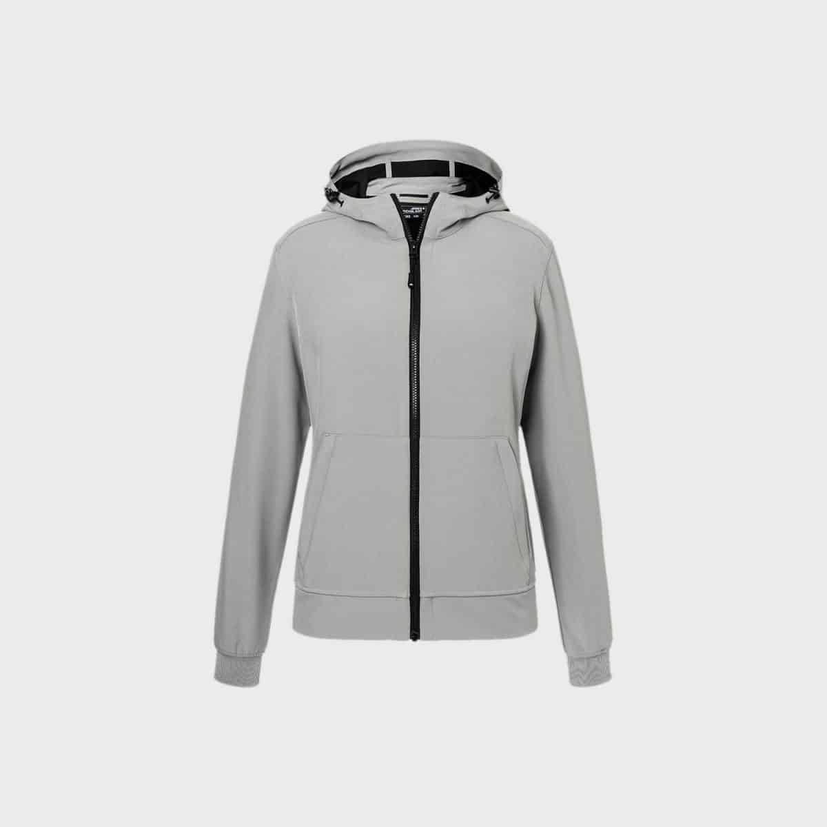 Die Softshelljacke mit Kapuze für Herren in Hellgrau hat einen durchgehenden schwarzen Reißverschluss und Kordelzüge. Sie verfügt über zwei Vordertaschen, gerippte Bündchen und besticht durch ein schlichtes, aber modernes Design, das sie perfekt für die Freizeit macht. Der Hintergrund ist schlicht weiß.