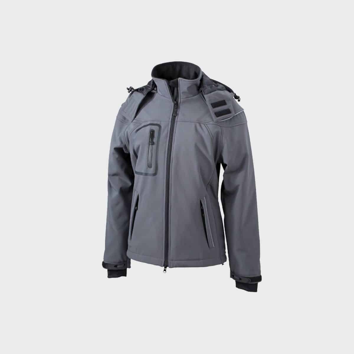 Eine graue Jacke mit durchgehendem Reißverschluss und Kapuze, schwarzen Schulteraufnähern und mehreren Reißverschlusstaschen. Die Jacke hat verstellbare Bündchen und Kordeln an der Kapuze und ist für den Einsatz im Freien oder im Einsatz konzipiert. Sie ist auf einem schlichten hellgrauen Hintergrund abgebildet.
