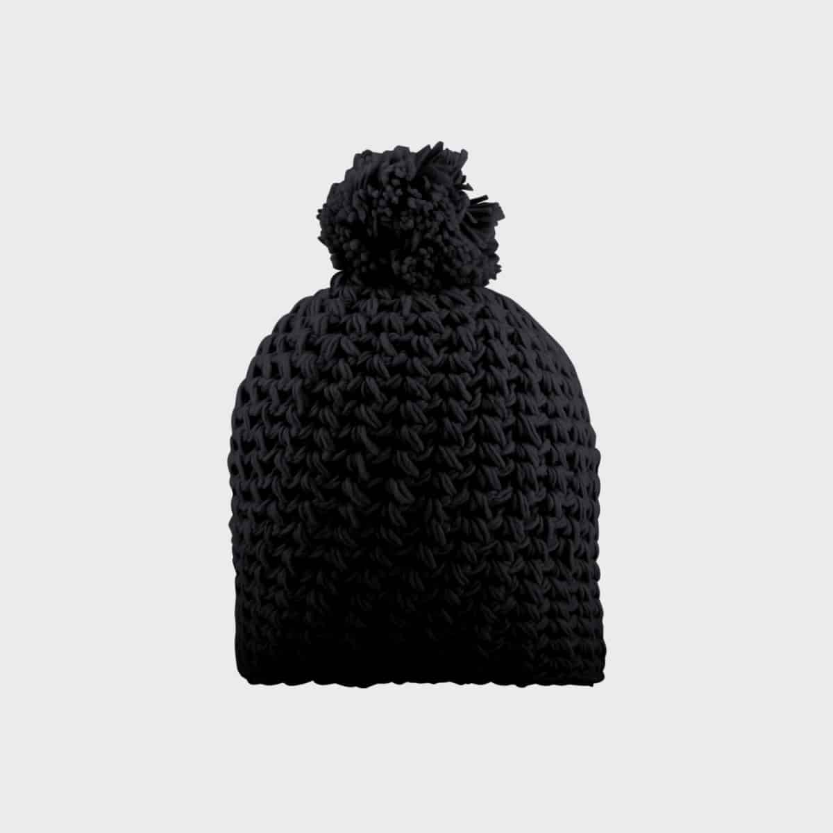 Eine schwarze, grob gestrickte Wintermütze mit einem großen Bommel oben drauf. Die Mütze hat ein dickes, strukturiertes Muster und ein eng anliegendes Design vor einem schlichten hellgrauen Hintergrund.