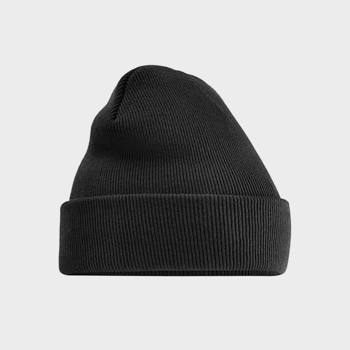 Eine schwarze, gerippte Strickmütze mit gefalteter Krempe auf einem schlichten hellgrauen Hintergrund. Die Mütze hat ein einfaches und klassisches Design, das für kaltes Wetter geeignet ist.